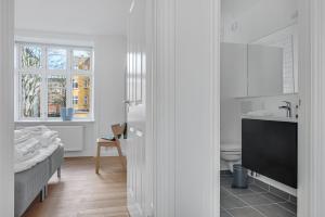 NABO Hotel Apartments في كوبنهاغن: حمام أبيض مع حوض ومرحاض