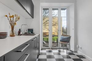 a white kitchen with a black and white checkered floor at NABO Hotel Apartments in Copenhagen