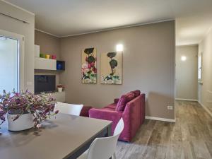 uma sala de estar com um sofá rosa e uma mesa em Apartment Cà Ben-2 by Interhome em Dongo