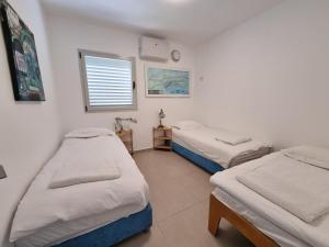 een kamer met 2 bedden en een raam bij Beachfront Gallery in Akko