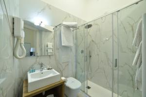 ein Bad mit einer Dusche, einem Waschbecken und einem WC in der Unterkunft Hotel Europa & Concordia in Alassio