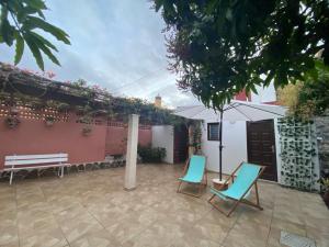 un patio con due sedie e un ombrellone di Casa Pepa y Argeo a Mazo