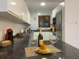 una bottiglia di vino e due bicchieri da vino su un bancone di Casa Pepa y Argeo a Mazo