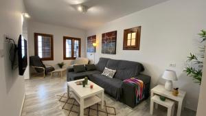 un soggiorno con divano nero e tavolo di Casa Pepa y Argeo a Mazo