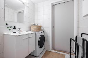 a white laundry room with a washer and dryer at Hotel suite apartment in Oslo