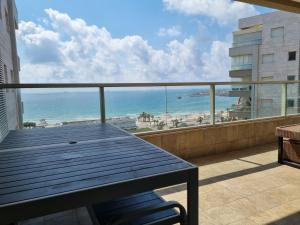 a balcony with a table and a view of the beach at Beachfront Gallery in ‘Akko