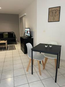 een woonkamer met een zwarte tafel en stoelen bij Charmant Studio l'Arnon à Issoudun in Issoudun