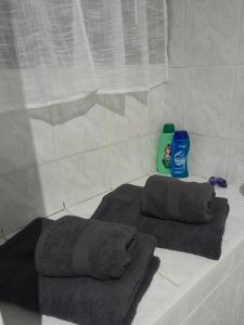 een bad met 2 handdoeken en een fles schoonmaakmiddel bij Charmant Studio l'Arnon à Issoudun in Issoudun