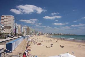 a beach with people on the sand and the ocean at L Appart’ Grande Plage in Les Sables-dʼOlonne