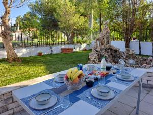 a white table with plates and bowls of fruit on it at Four seasons apartment in Artemida