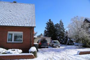 a house with two cars parked in the driveway at Refugium in Nortrup in Nortrup