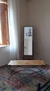 een houten bank in een kamer met een spiegel bij Old Street in Koetaisi