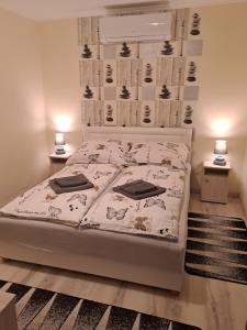 sypialnia z białym łóżkiem z 2 lampami w obiekcie Katarina apartman w Hajduszoboszlo