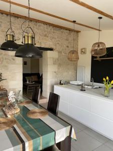 Saint-Michel-de-Fronsac的住宿－Le Petit Chai Fronsadais，厨房以及带桌椅的用餐室。