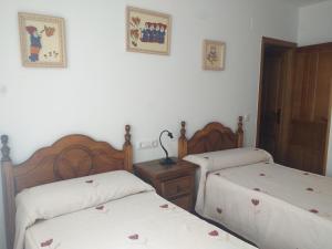 コト・リオスにあるAlojamiento aguasblanquillasの白い壁のベッドルーム1室(ベッド2台付)
