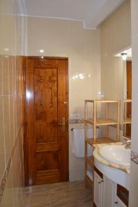 a bathroom with a wooden door and a sink at Casa Rural Natalia in Valmuel +17 photos