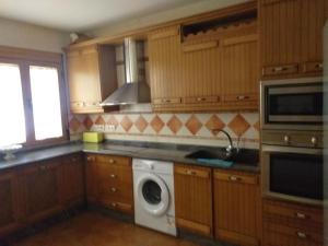 a kitchen with a washing machine and a microwave at Alojamiento aguasblanquillas in Coto Ríos