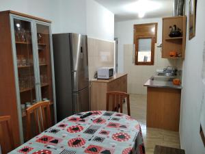 a kitchen with a table and a refrigerator at Casa Rural Natalia in Valmuel