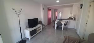 sala de estar con TV y mesa con sillas en Apartamento La Puntica, en San Pedro del Pinatar