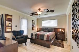 ein Schlafzimmer mit einem Bett, einem Stuhl und einem TV in der Unterkunft Galveston Escape with Entertainment Patio and Deck! in Galveston
