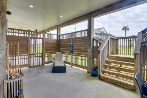 einen Balkon mit Holzgeländer und Treppen in einem Haus in der Unterkunft Galveston Escape with Entertainment Patio and Deck! in Galveston