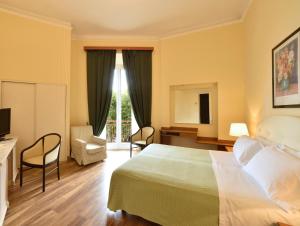 Pokój hotelowy z łóżkiem, biurkiem i krzesłem w obiekcie Hotel Europa & Concordia w Alassio