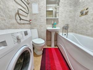 a washing machine in a bathroom with a toilet and a sink at Sapar APARTMENTS 1 in Aktobe