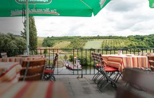 a patio with tables and chairs and a view of a field at Gasthof zum Schiff in Obereisenheim