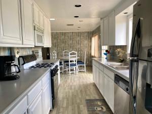 a kitchen with white cabinets and a stove top oven at Rancho Dominique Valle de Guadalupe in Valle de Guadalupe