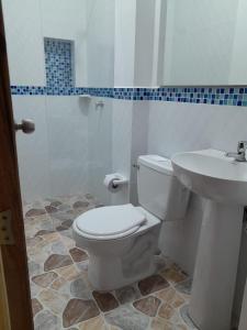 y baño con aseo y lavamanos. en Hotel Santa Fe del Parque, en Santa Fe de Antioquia