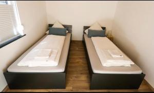two beds in a small room in a bedroom at B&B Malú am Ring in Müllenbach