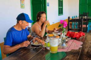 聖吉爾的住宿－La Hacienda，坐在餐桌旁吃食物的男人和女人