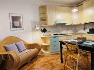a kitchen with a couch and a table with chairs at Il palombaro bianco in Pugliola +4 photos