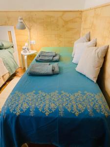 un letto con lenzuola e cuscini blu; di Il palombaro bianco a Pugliola