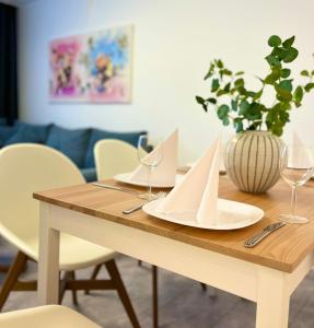 Ferienwohnung Bloom في بيرنكاستل كويز: طاولة غرفة الطعام مع الأطباق البيضاء وكؤوس النبيذ