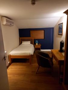 1 dormitorio con cama, escritorio y silla en The Renishaw Rooms, en Renishaw