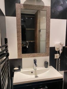 a bathroom with a sink and a mirror at Lovely 1-bedroom apartament with free parking in Sofia