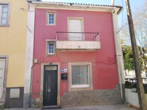 a red building with a balcony and a door at AL Penaferrim Sintra Rooms in Sintra