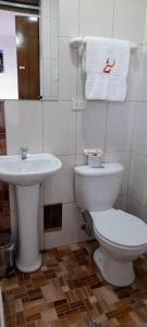 a bathroom with a white toilet and a sink at Posada SAQRA Cusco in Cusco