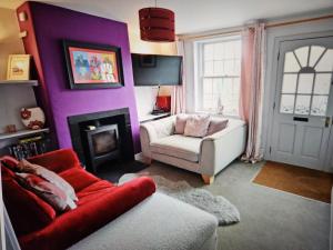 Shottery的住宿－Cherry Blossom Cottage ,4 Cherry Street , Old Town ,Stratford Upon Avon，紫色的客厅配有沙发和椅子