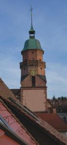 einen Uhrturm mit einem Kreuz auf einem Gebäude in der Unterkunft Helles modernes City-Loft in Freudenstadt
