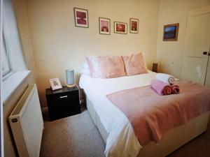 um quarto com uma cama grande e almofadas cor-de-rosa em Cherry Blossom Cottage ,4 Cherry Street , Old Town ,Stratford Upon Avon em Shottery