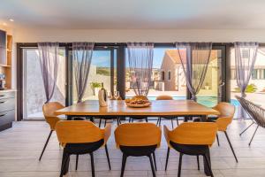 a kitchen and dining room with a wooden table and chairs at Villa TM with private heated pool, poolhouse & private garage in Milna