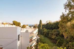 Vista árida de un edificio blanco y árboles en Piso precioso con vistas al mar., en Nerja