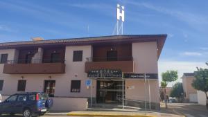 a building with a car parked in front of it at HOTEL NUEVO ESPARTINAS in Espartinas
