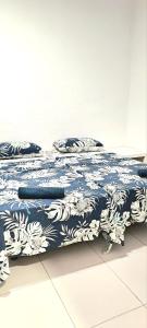 a bed with a blue and white blanket and pillows at La MARINA in Alicante