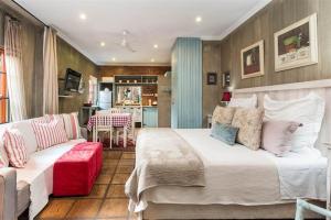 um quarto com uma cama grande e um sofá em Ambiance Guesthouse em Pretoria