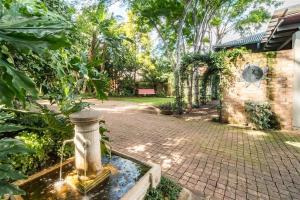 a garden with a fountain in the middle of a yard at Ambiance Guesthouse in Pretoria