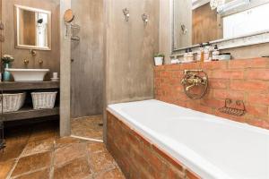 uma grande casa de banho com banheira e lavatório em Ambiance Guesthouse em Pretoria