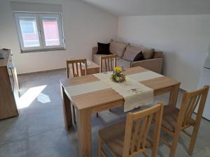 a living room with a wooden table and chairs at Apartments Sofie & Emily in Gornji Karin